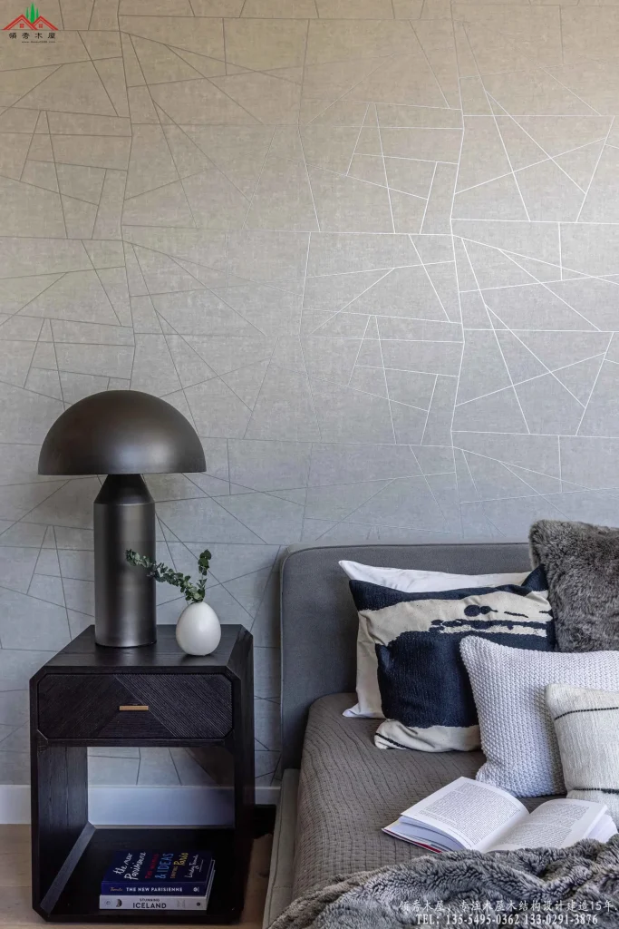 卧室几何壁纸,深色床头柜与艺术台灯。