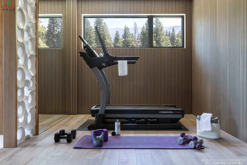 室内健身房,木质条纹墙面与落地窗外森林景致。